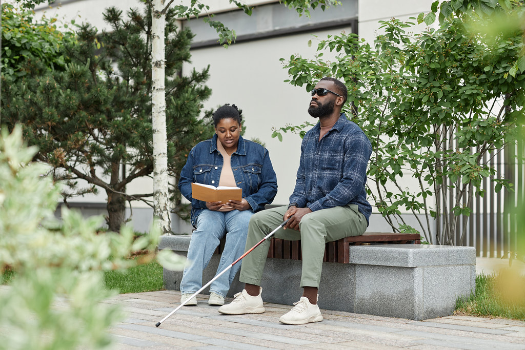 blind man sitting on bench with woman