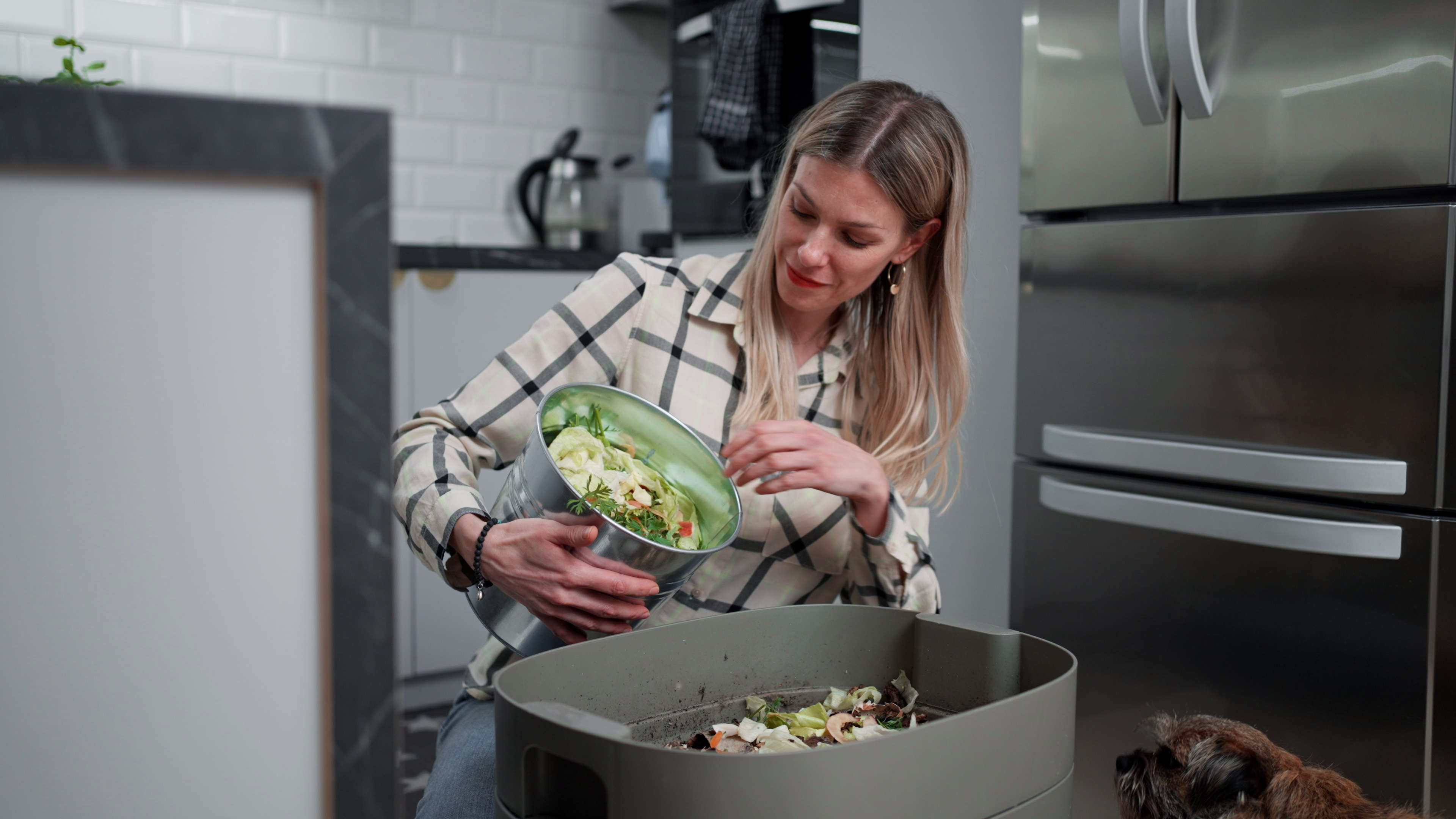 A woman composting in the kitchen