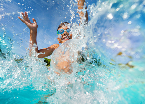 young child jumping into a pool